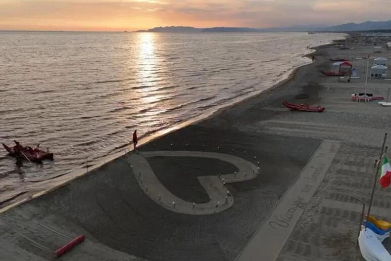 Un grande cuore sulla sabbia e 32 fiori in ricordo delle vittime della strage di Viareggio